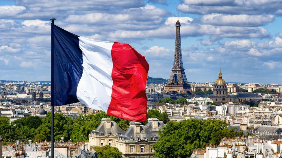 Image représentant la France via des symboles forts. Le drapeau français au premier plan et la tour eiffel en arrière-plan.